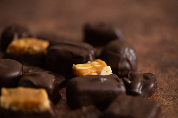 Chocolate candy box. Mix chocolate candy, sweet snack, brown background. Assorted chocolates, macro, horizontal