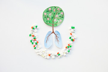 Watercolor illustration of human lungs in form of tree and roots surrounded by pills on white background . The concept of protecting planet, ecology, human health, against viruses, pollution