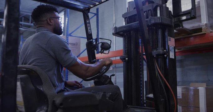 Manager in shipping warehouse using forklift