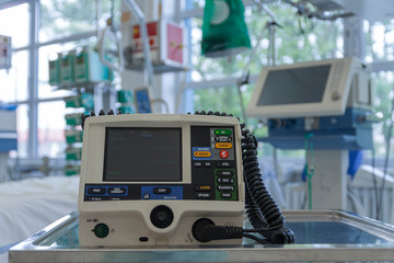 Defibrillator,  on background medical ventilator in ICU in hospital, a place where can be treated patients with pneumonia caused by coronavirus covid 19.