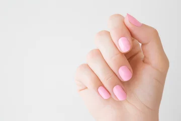 Wanddecoratie Nagelstudio Beautiful groomed woman hand with pastel pink nails on light gray background. Manicure, pedicure beauty salon concept. Empty place for text or logo. Closeup.  © fotoduets