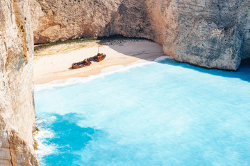 Empty Navagio beach. Turquoise blue sea cove surrounded by huge white limestone cliffs on sunny...