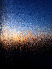 Drops of water on a glass in blue in the morning.