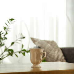 Spring time and wooden desk in home interior with blurred window. 