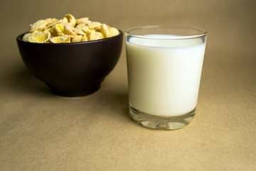 Flakes in a clay bowl and a glass of milk