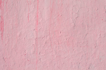 Fragment of old house wall close-up. Pink background. Peeling plaster on concrete surface. Cracks in paint. Copy space. Place for text. Selective focus image.