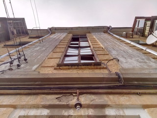 Bottom-up view of the facade of the old 19th century green low-rise house.