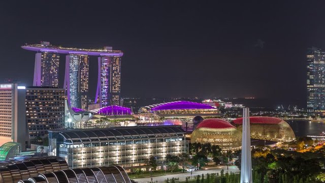 Fifty-five storeys high Marina Bay Sands Hotel dominates the skyline at Marina Bay in Singapore aerial night timelapse. Fountains with laser light show. Esplanade theathe