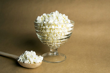 Cottage cheese in a glass cup, on a black background