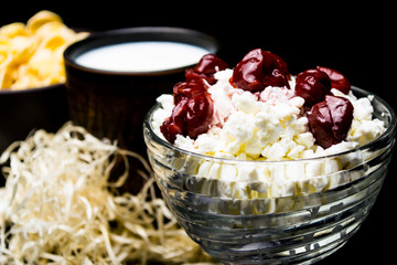 Cottage cheese in a glass cup, on a black background