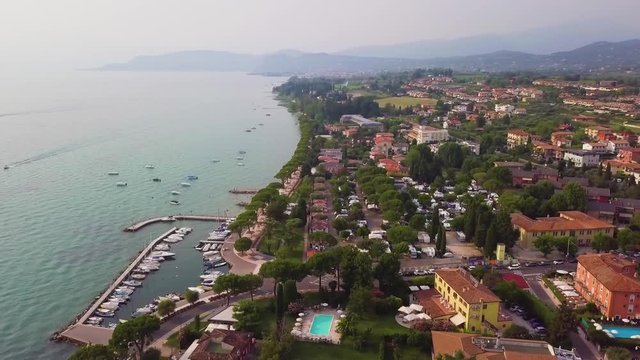 4K Aerial video with drone. Panoramic view of the resort town of Lazise on Lake Garda, north of Italy. Boat parking in the city.