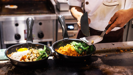 Bibimbap (Korean rice mixed with kimchi pork, seaweed and stir fried vegetables topping with sesame) served on the hot pan. Prepared fried rice with steam before adding toppings.