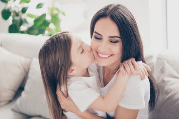 Obraz na płótnie Canvas Closeup photo of pretty little girl kissing cheek young charming attractive mommy hugging holding each other close sitting comfy sofa spend time together home house indoors