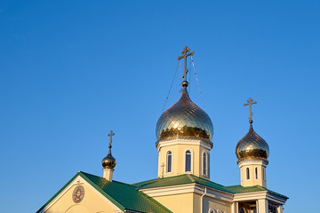 Fototapeta na wymiar Eastern orthodox crosses on gold domes cupolas againts blue sky without clouds