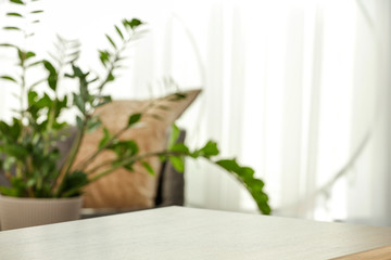 Spring time and wooden desk in home interior with blurred window. 