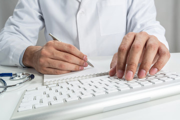 Doctor typing on wireless computer keyboard