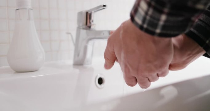 Close up of Caucasian male hands. Man washing and rubbing hands with soap and foam in bathroom. Self hygiene. Safe quarantine. Coronavirus disinfection. Fingers clean wash. Sanitary concept.