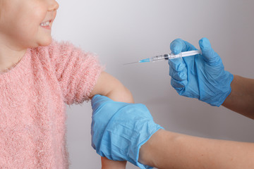 a little girl gets vaccinated on a white background in a Studio. vaccine, inoculation