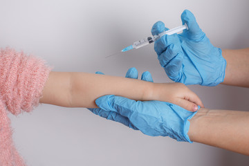 a little girl gets vaccinated on a white background in a Studio. vaccine, inoculation