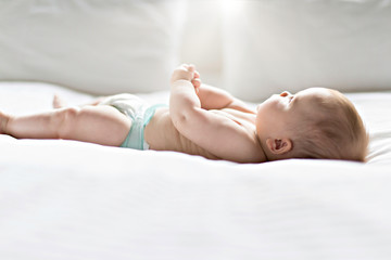 Cute happy 7 month baby girl lying on bed