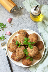 Homemade juicy delicious meat cutlets in plate, meatballs from minced meat on a gray stone table. Copy space.