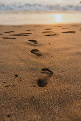  Footprints in the sand on a Balinese beach during sunset
