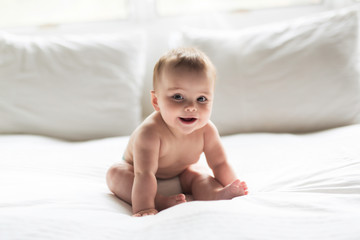 Cute happy 7 month baby girl lying on bed