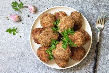 Homemade juicy delicious meat cutlets in plate, meatballs from minced meat on a gray stone table....
