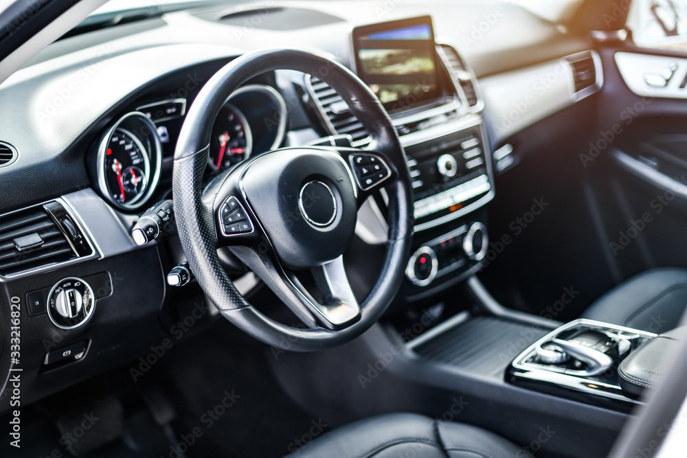 Wall mural interior view of car, luxury car steering wheel and clean dashboard with display or monitor screen.