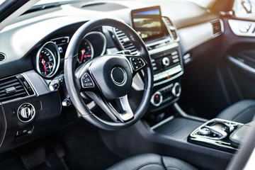 Interior view of car, Luxury car steering wheel and clean dashboard with display or monitor screen. - obrazy, fototapety, plakaty