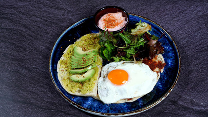 Avocado egg, tomato sauce and fresh salad