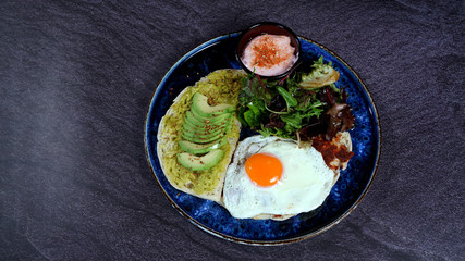 Avocado egg, tomato sauce and fresh salad