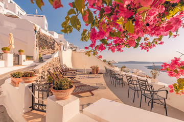 Beautiful terrace with flowers and chairs and loungers, sea view. Santorini island, Greece.