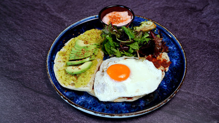Avocado egg, tomato sauce and fresh salad