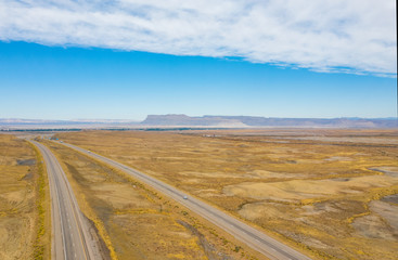 Fototapeta na wymiar Aerial top view of nature landscape. Blue sky with clouds, highway road, mountains, on background. USA country