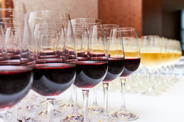 glasses with red and white wine on a white table