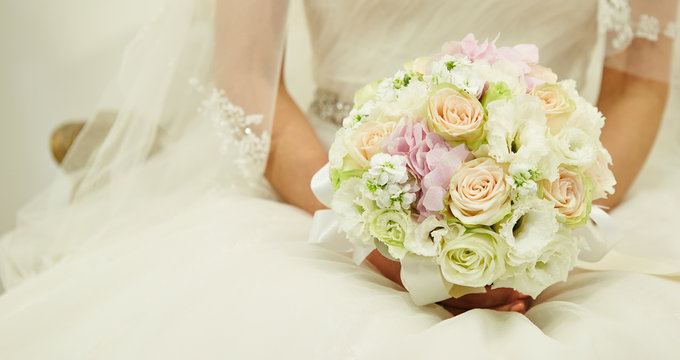 Bride in wedding dress holding flower bouquet 