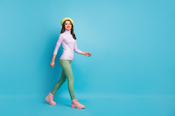 Full length profile photo of pretty tourist lady walk street abroad traveler wear green beret purple turtleneck jumper pants boots isolated blue color background