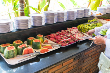 Sliced exotic fruits and stacks of clean plates in a restaurant