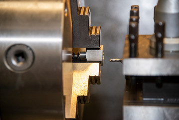 The operation of lathe machine cutting the metal shaft parts with. The metalworking process by turning machine.