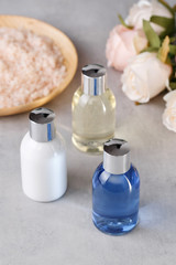 Three color bottles on a grey background. Spa items for body care and hygiene. Beauty concept.