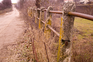 Destroyed reinforced concrete handrails. The destroyed old bridge. Old bridge in the village.
