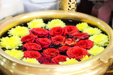Red Roses Surrounded By Yellow Flowers In Circular Or Round Shape Dip in Water In Brass Metal Container At Hotel Or Office Reception For Welcoming Guests And Decoration