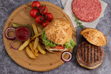 Tasty grilled home made burgers with beef, tomato, cheese, cucumber and lettuce. Top view. Flat lay