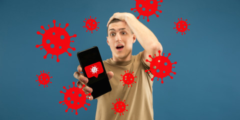 Young man using phone, watching news of coronavirus spreading and worldwide cases, shocked and sad. Flu virus protection, prevention, treatment. Healthcare and medicine. Viruses illustration. Ad.