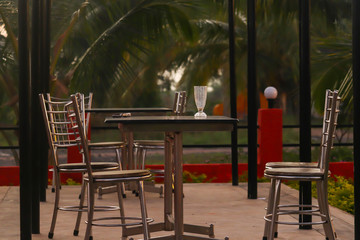 Fototapeta na wymiar Evening View Of Outdoor Open Chairs and Table At Terrace Garden Of Cafe Or Restaurant In India