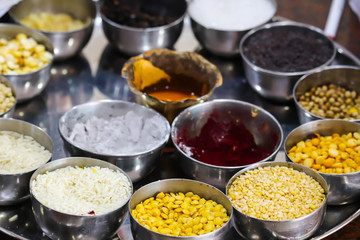 Various Types Of Crops And Asian Food Grains In Bowls With Sacred Colorful Powders In Thali At Hotel Reception In South India For Offering To God And Welcoming Of Guests