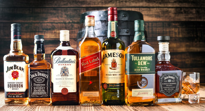 VAVRISOVO, SLOVAKIA - SEPTEMBER 14, 2019: Famous whiskey bottles and whisky barrel, The most popular liquor in the world. Alcohol drink wide banner or panorama concept.