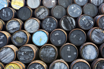 Stacked pile of old wooden barrels and casks at whisky distillery in Scotland