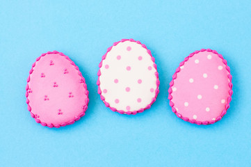 Easter background concept. Polka dot easter egg cookies on a blue background.